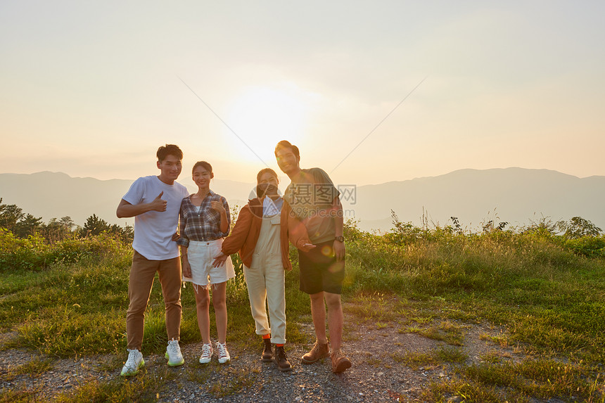 青年朋友结伴旅行看夕阳图片