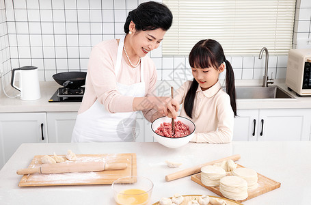 厨房里奶奶教孙女拌肉馅背景图片