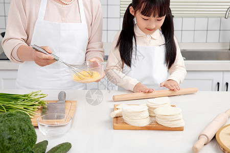 奶奶和孙女一起在厨房包饺子高清图片