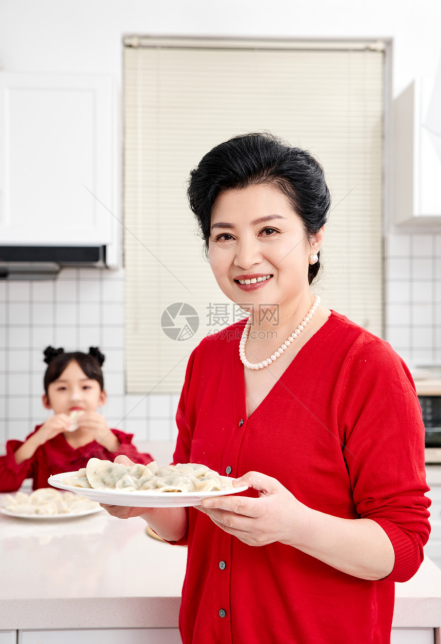 厨房里奶奶端着煮好的饺子图片