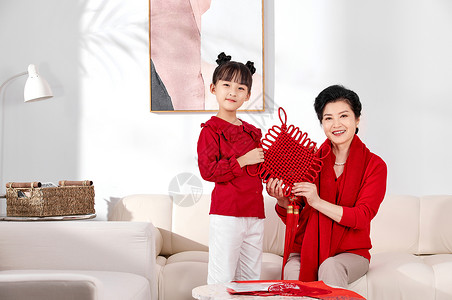 孙女和奶奶展示新春中国结背景图片