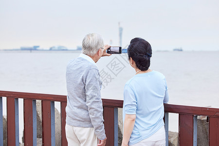 老年夫妇江边户外散步背影图片