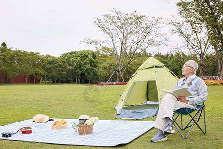 老年男性户外野餐手拿书本享受生活图片