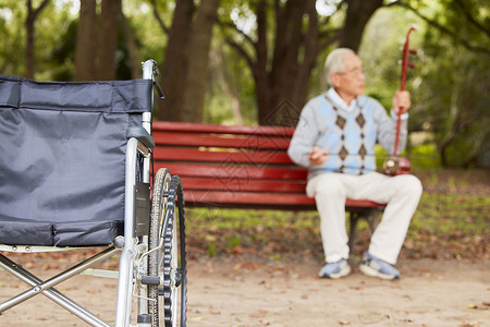 钓鱼老人素材长椅上的孤独老人拉二胡背景