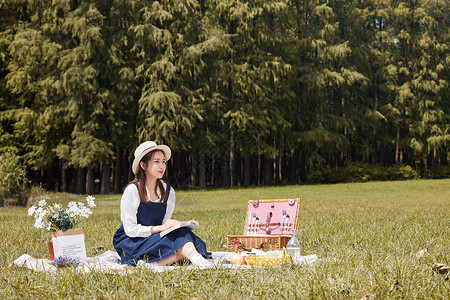 草帽青年美女大学生公园野餐阅读看书背景