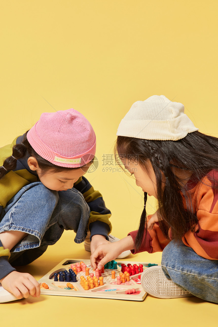 双胞胎小女孩姐妹坐着玩跳棋图片