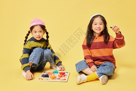 双胞胎小女孩姐妹坐着玩跳棋图片
