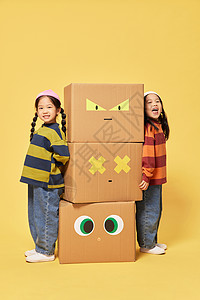 双胞胎小女孩躲在创意纸盒箱旁边图片