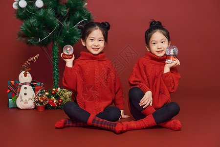 双胞胎小女孩过圣诞节拿水晶球图片
