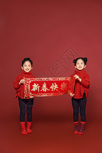 新年春节双胞胎女孩拿春联背景图片