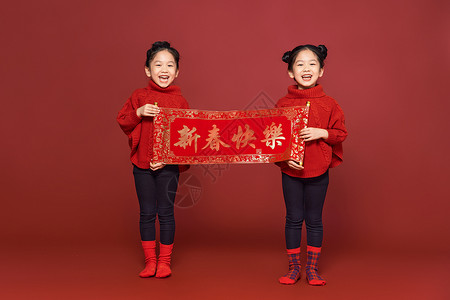 新年春节双胞胎女孩拿春联图片