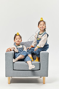 坐巴士小女孩双胞胎小女孩坐沙发上玩小鸭子玩具背景
