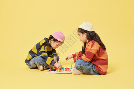 双胞胎小女孩坐地上下跳棋图片