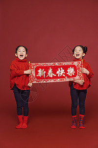 双胞胎小女孩姐妹新年拿春联背景图片