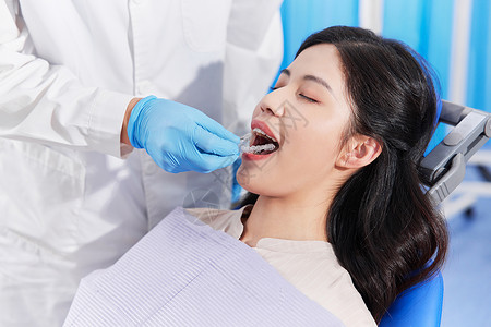 治疗牙齿牙医为患者佩戴牙齿矫正器背景