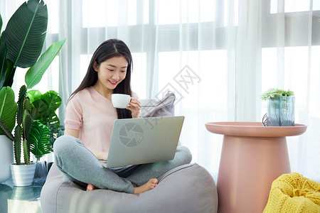 女性休闲居家生活阳台上看笔记本喝咖啡高清图片