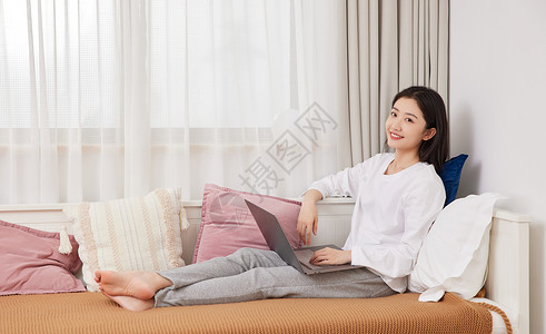 美女居家坐在沙发上休闲生活上网图片