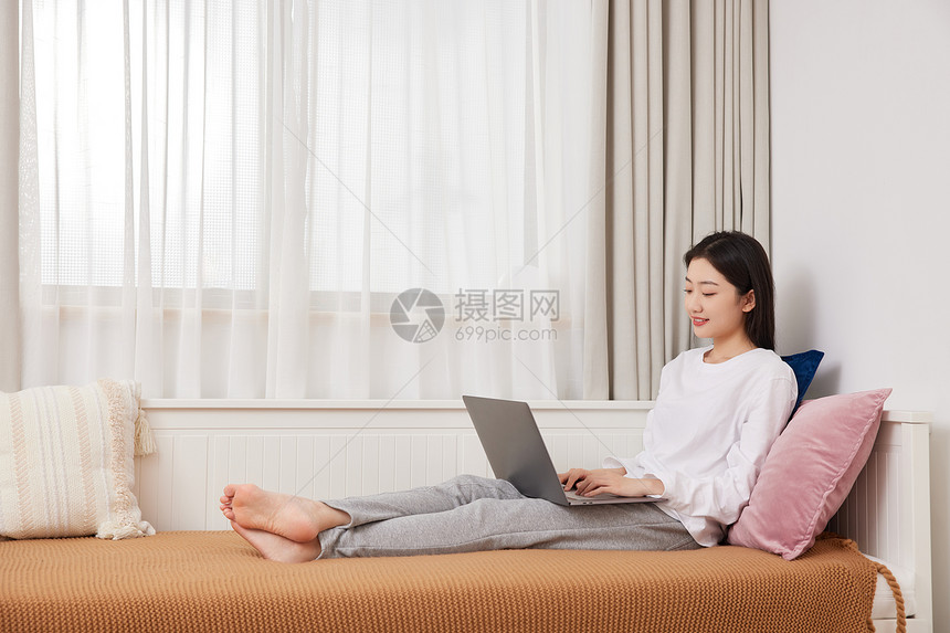 美女居家坐在沙发上休闲生活上网图片