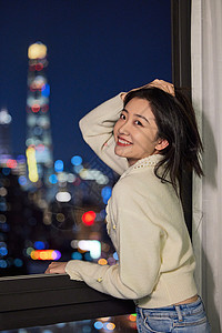 单身美女度假阳台窗边观赏上海夜景图片