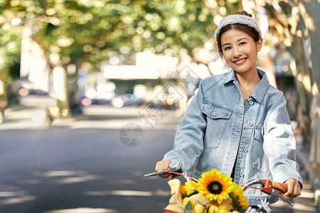 清新美女骑自行车出游逛街背景图片