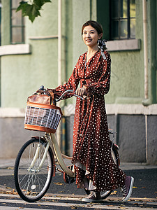 清新美女出游推着自行车过马路高清图片