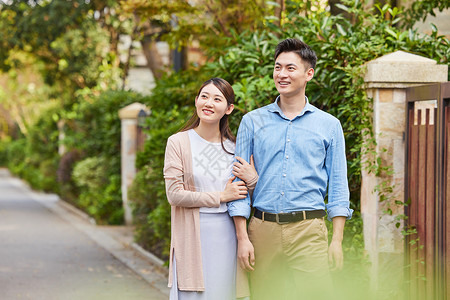 高档小区散步的年轻夫妇背景图片