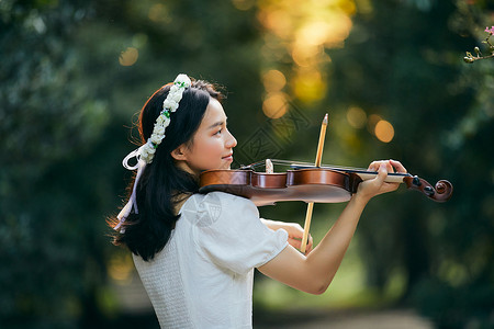 小提琴户外活动夕阳余晖中拉小提琴的少女背景