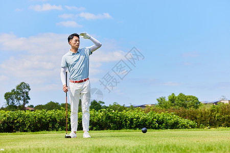 手握球男性手握高尔夫球杆眺望远方背景