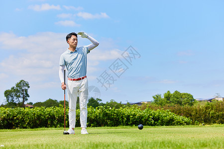 男性手握高尔夫球杆眺望远方背景图片