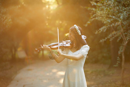 小提琴户外活动夕阳余晖中拉小提琴的少女背景