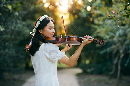 陶醉女孩夕阳余晖中拉小提琴的少女背景