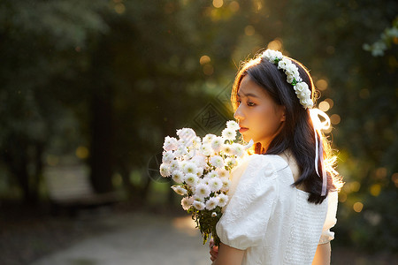 逆光少女夕阳下拿着花的少女背景