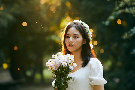 美女悠闲下午夕阳下拿着花的少女背景