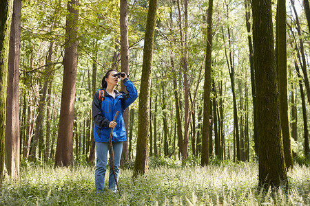 森林徒步女生使用望远镜图片