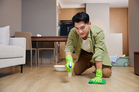 年轻男性居家清洁木地板高清图片