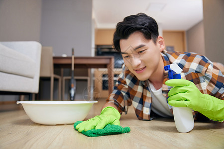 年轻男性居家清洁木地板高清图片