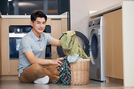 男青年居家使用洗衣机洗衣服图片