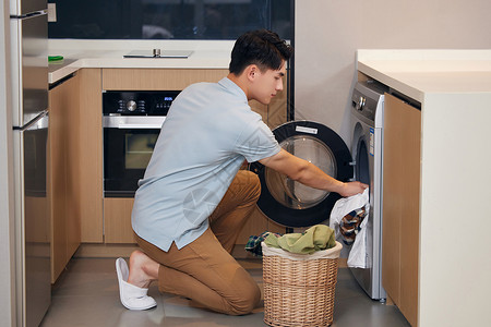 烘干衣服年轻男士在家使用洗衣机洗衣服背景