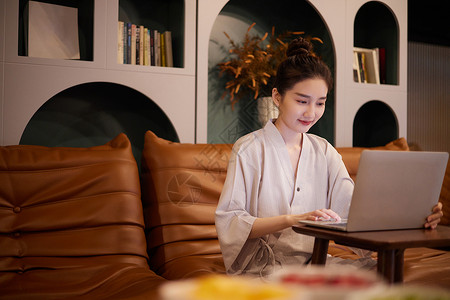 青年女性在汤泉馆公共区域使用电脑背景图片