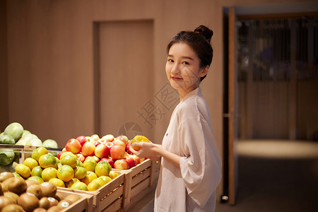 桑拿馆青年美女在汤泉馆美食区域挑选水果背景
