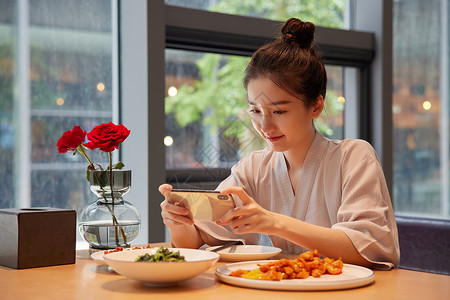 美食拍照青年女性吃饭用手机拍照记录美食背景