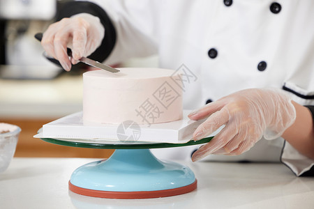 烘焙师使用刮刀抹奶油特写背景