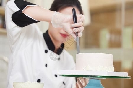 女性烘焙师使用刮刀抹奶油高清图片