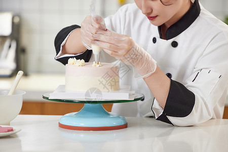 烘焙师图片青年女西点师为蛋糕裱花特写背景