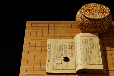 棋文化围棋棋盘上的棋子和书背景