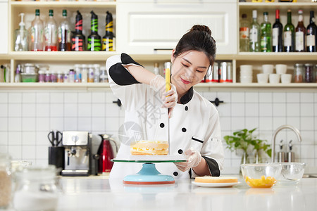 女性烘焙师使用刮刀抹奶油图片素材