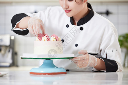 女性烘焙师装饰蛋糕特写图片