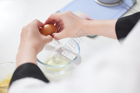 烘焙师制作面点打鸡蛋特写高清图片