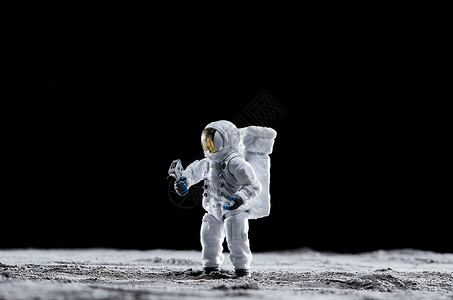 站在月球表面手拿探测器的宇航员图片