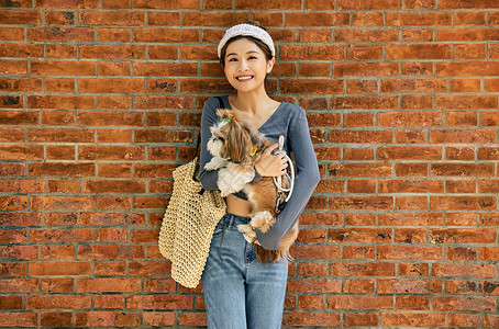 清新美女抱着宠物狗出游逛街高清图片